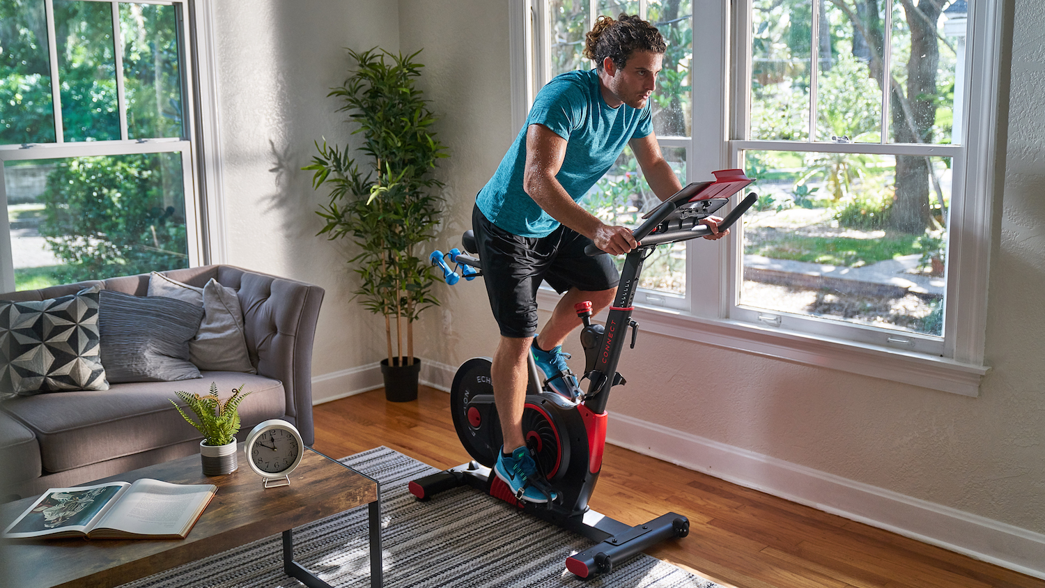 Test du vélo Echelon Smart Connect EX3 Max : un homme fait de l'exercice dans son salon avec le vélo Echelon